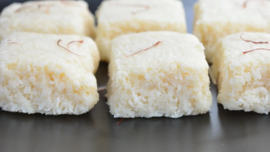 U jednoj šerpici pomiješajte kokos sa kondenzovanim mlijekom, pa zakuhajte na tihoj vatri, dok smjesa ne postane kompaktna